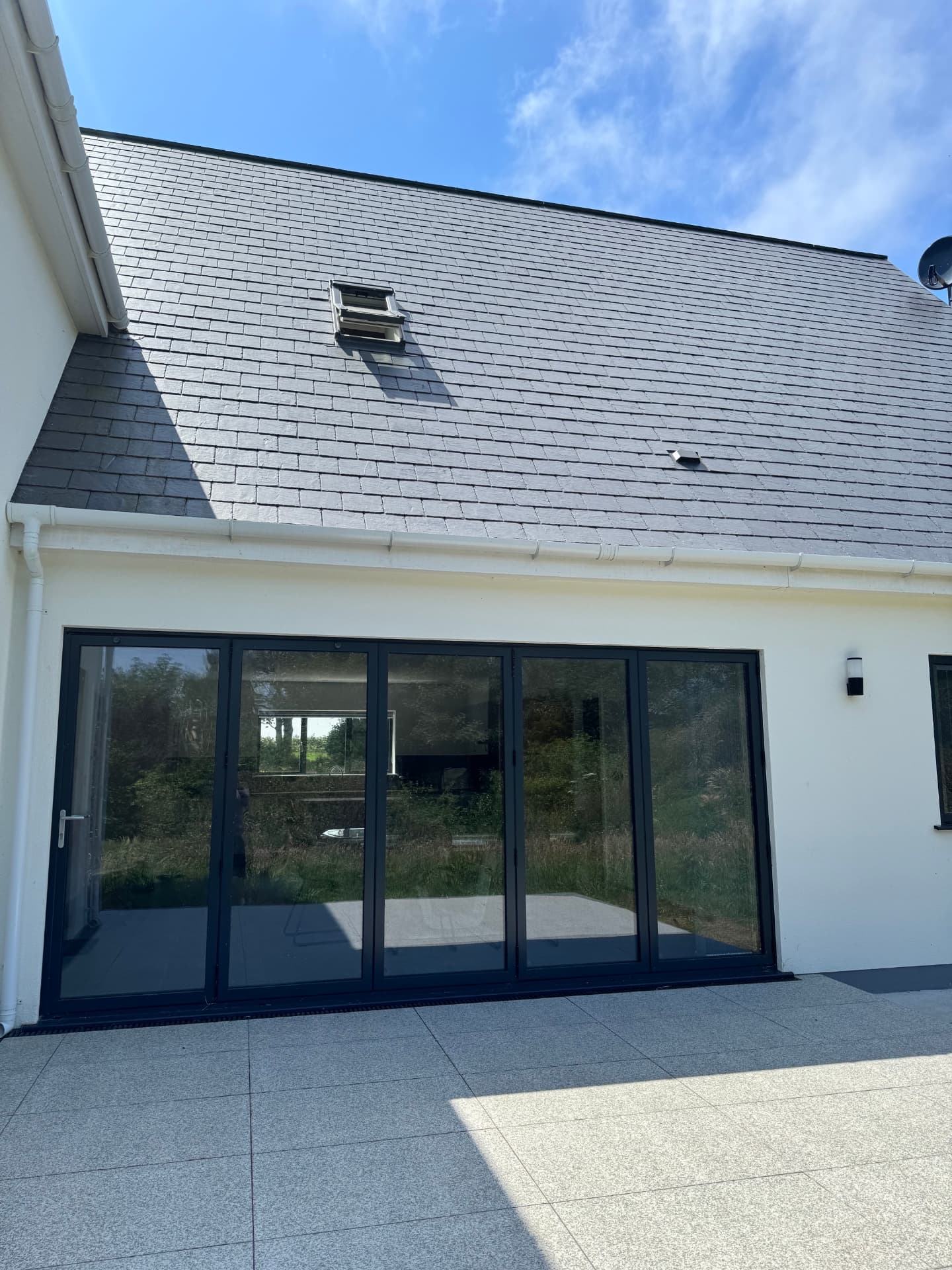 Slate roof and bi-fold doors onto the finished patio of the newbuild