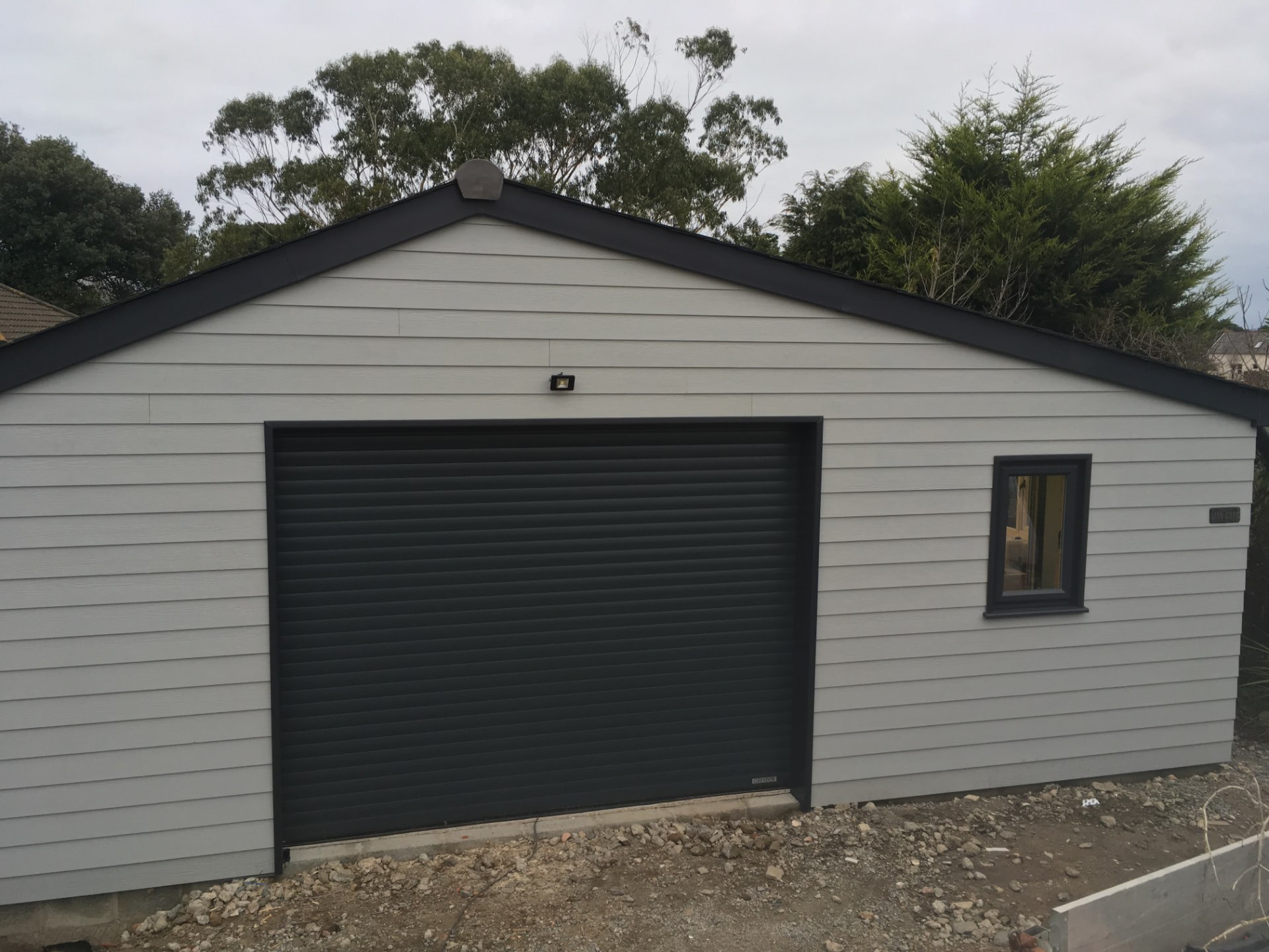 A newly built cladded double garage with roller shutter door